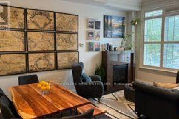 Living room with a fireplace, dark armchair, and framed world maps on the wall. - 1042 Avenue Road, Toronto
