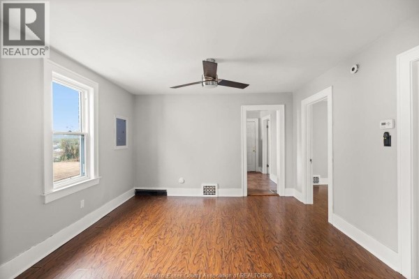 Living room with light grey walls, wood floors, ceiling fan, and interior doorways. - 1044 Parent Avenue Unit# Upper, Windsor