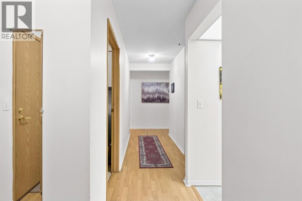 Long hallway with light-colored walls, carpet runner, and a ceiling light fixture. - 1045 Sutherland Avenue Unit# 214, Kelowna