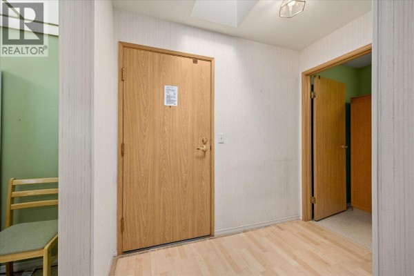 Dining area with wooden table, chairs, and a view into the living space - 1045 Sutherland Avenue Unit# 306, Kelowna