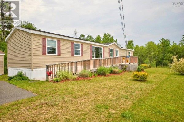 Front exterior of a beige and tan mobile home with a long wooden ramp and deck. - 1047 Glen Forest Drive, Westville