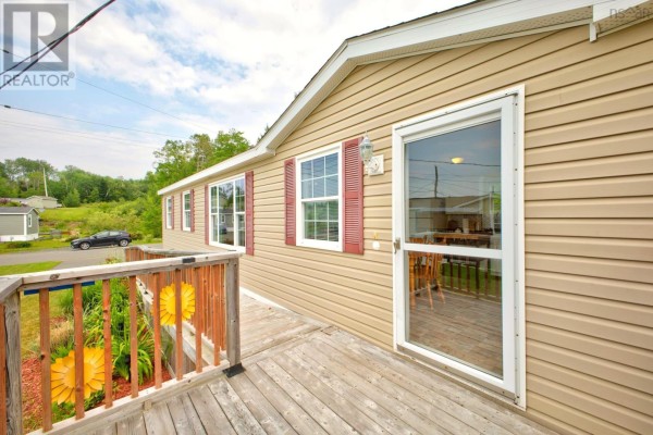 Close-up of the wooden deck and glass door on the side of a mobile home. - 1047 Glen Forest Drive, Westville