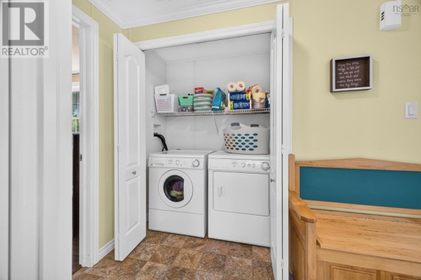 Interior hallway closet with a white washer and dryer, shelving, and storage baskets. - 1047 Glen Forest Drive, Westville