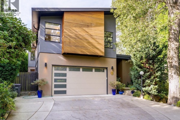 Modern two-story house exterior with garage and wood accents during the day. - 1047 San Marino Cres, Saanich