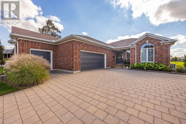 Front exterior of a brick house with a three-car garage and a paved driveway. - 1048 Sandy Somerville Drive, London South