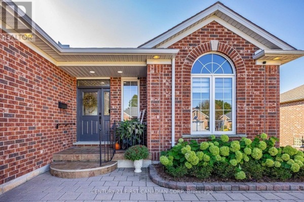 Front entrance of a brick house with a glass door, arched window, and stone walkway. - 1048 Sandy Somerville Drive, London South