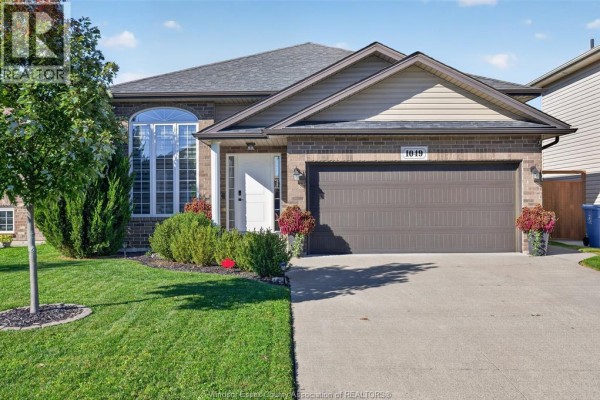 Close-up of the front entrance of a brick house with manicured landscaping. - 1049 Thunderbay, Windsor