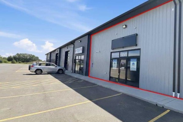 Parking lot view with multiple vehicles and commercial buildings in the background. - 105, 245 Canal Avenue, Strathmore