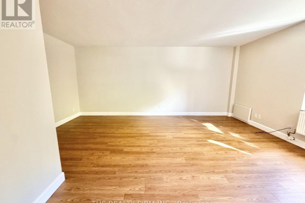 Living room with wood-look flooring and beige walls. - 105 - 10 Beechwood Place, London South