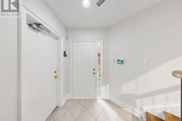 Interior view of a bright foyer with a white front door and tiled floor. - 105 - 105 Leah Crescent, Vaughan
