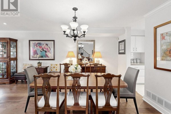Dining area with a wooden table, chairs, cabinet, and view into the kitchen. - 105 - 105 Leah Crescent, Vaughan