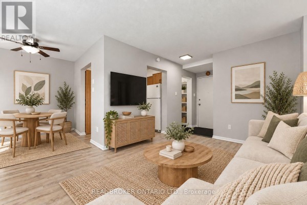 Open concept living and dining area with a sofa, dining set, light wood floors, and hallway. - 105 - 2044 Arrowsmith Drive, Ottawa