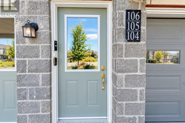 Close-up of the light green front door with gold hardware and house numbers 106, 105, 104. - 105 - 2540 William Jackson Drive, Pickering