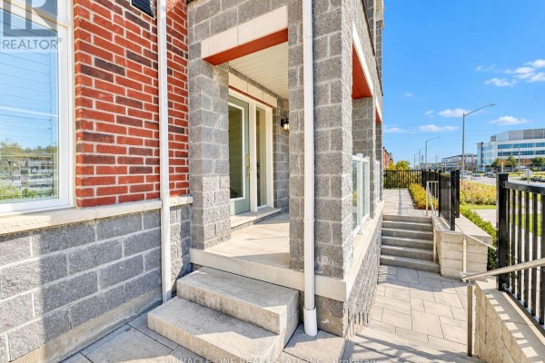 Entrance porch with concrete steps and columns, leading to a white door with a glass panel. - 105 - 2540 William Jackson Drive, Pickering