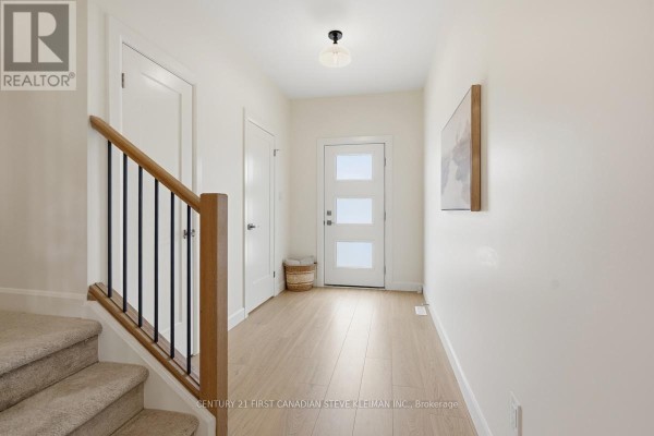 Bright entryway with stairs, light wood flooring, white walls, and a frosted glass door. - 105 - 2840 Buroak Drive, London North