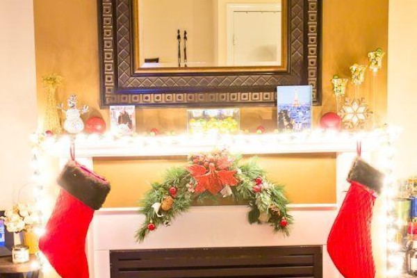 Fireplace with a white mantel decorated for Christmas, featuring stockings and garland. - 105 - 3 Everson Drive, Toronto
