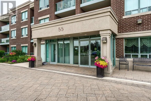 Close-up of the main entrance at 55 Via Rosedale Road with double glass doors and planters. - 105 - 55 Via Rosedale Road, Brampton