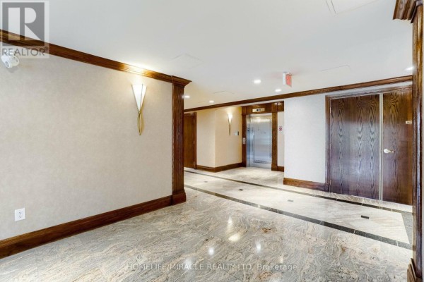 Interior building hallway with marble floors, wood trim, and elevator doors. - 105 - 55 Via Rosedale Road, Brampton