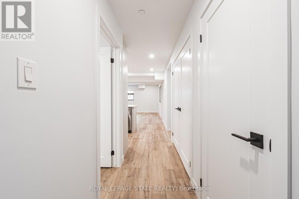 Hallway leading into an open-concept living space with white doors on the right. - 105 - 555 Sanatorium Road, Hamilton