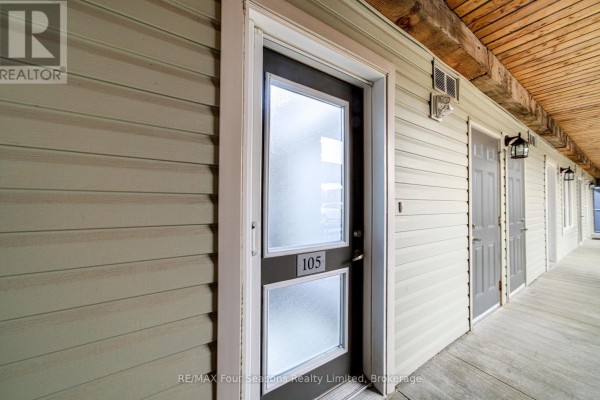 Exterior hallway of apartment building showing entrance door labeled 105. - 105 - 6 Brandy Lane Drive, Collingwood