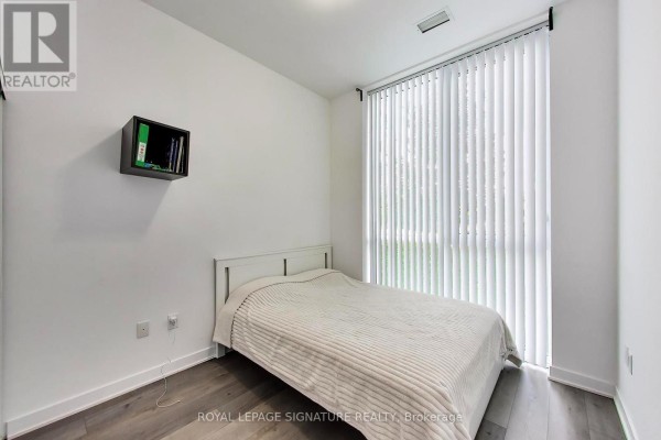 Bedroom with a queen-sized bed, white bedding, and vertical blinds covering a large window. - 105 - 60 Honeycrisp Crescent, Vaughan