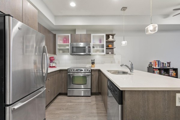 Kitchen with stainless steel refrigerator, oven, microwave, dishwasher, and island with sink. - 105 19936 56 Avenue, Langley