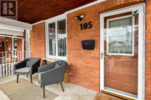 Covered porch with two chairs, brick wall, and mailbox at entrance. - 105 Barker Avenue, Toronto
