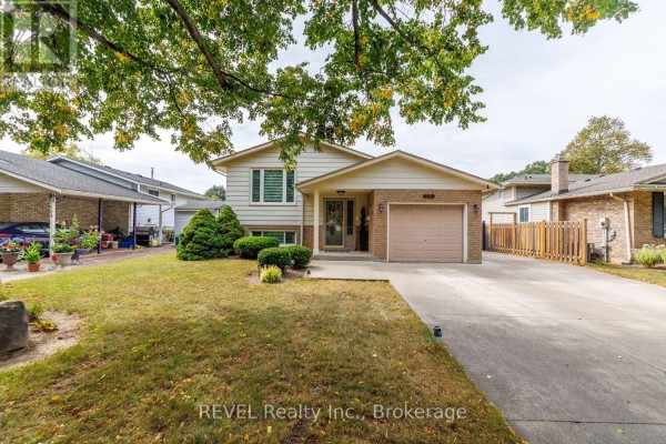 Front view of the bungalow from a lower angle, with grass and trees in the foreground. - 105 Elma Street, St  Catharines