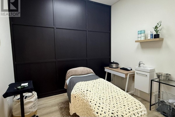 Small utility room with a sink, chair, cleaning supplies, and ring light. - 105 Garafraxa Street S, West Grey