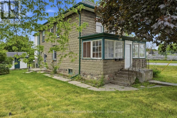 Compact kitchen with stainless steel appliances, wooden table, and decorative wall trim. - 105 Pine Street, Belleville