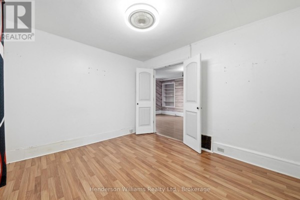 Narrow kitchen area with beige cabinets, white refrigerator, and access to an outdoor space. - 105 Pine Street, Belleville