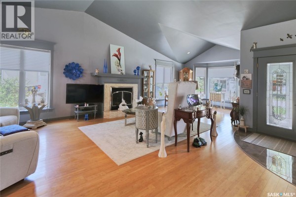 A view of a bright entryway with light gray walls, a white vanity, and double doors leading to a living space. - 105 Sargent Crescent, Lake Diefenbaker