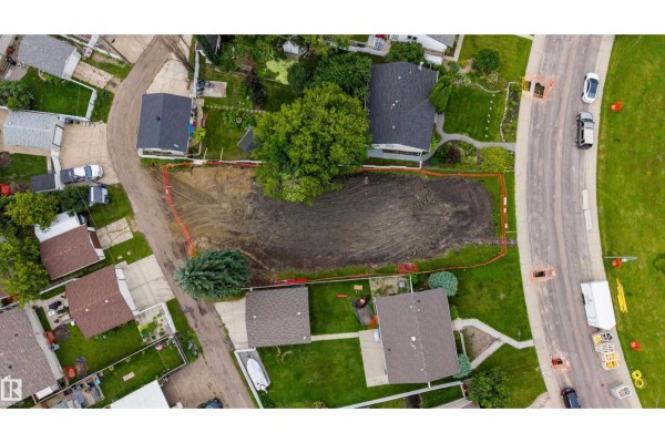 Top-down view of a cleared lot, showing the excavated earth and surrounding houses. - 10513 42 St Nw, Edmonton