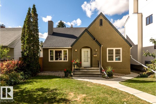 View of the front exterior of a stucco house with a pitched roof and landscaping. - 10514 127 Street Nw, Edmonton
