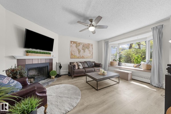 Entrance to unit 10518 with a white door, bay window, and small patio. - 10518 84 Av Nw, Edmonton
