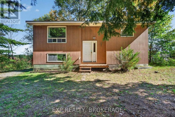 Front view of a light brown wood-sided house with a white door and porch. - 1054 York Road, Frontenac
