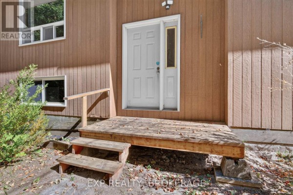 Close-up of the wooden porch steps and white front door of the house. - 1054 York Road, Frontenac
