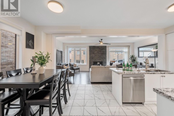 Open concept kitchen, dining area, and living room with a stone fireplace. - 1055 Skyridge Boulevard, Pickering