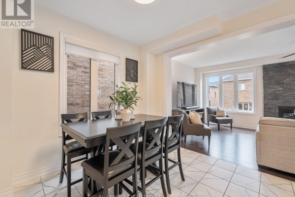 Dining area with a dark wood table and chairs, adjacent to the living room. - 1055 Skyridge Boulevard, Pickering