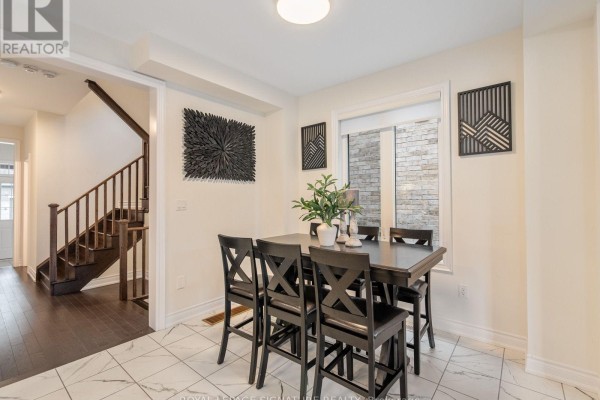 Dining area with a dark wood table and chairs and view of the staircase. - 1055 Skyridge Boulevard, Pickering
