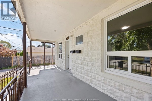 Covered porch area with white brick exterior walls and mailboxes. - 1056-1060 Niagara, Windsor
