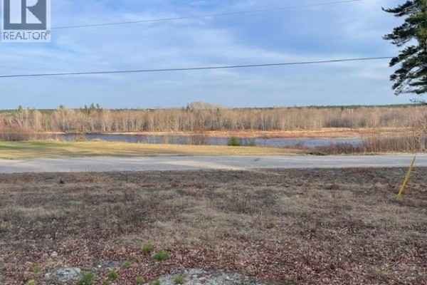 Drone shot showing the property and surrounding landscape with a frozen body of water. - 1056 Halcomb Road, Halcomb