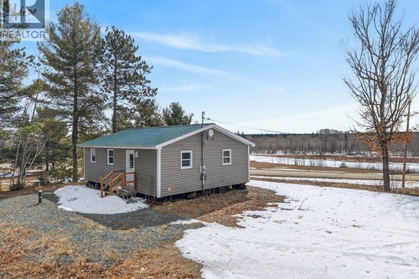 View of the property with multiple buildings nestled among pine trees and surrounding natural landscape. - 1056 Halcomb Road, Halcomb
