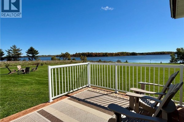Deck with chairs and a rug overlooks a grassy yard and a wide body of water. - 1056 N. Black River Road, Black River Bridge