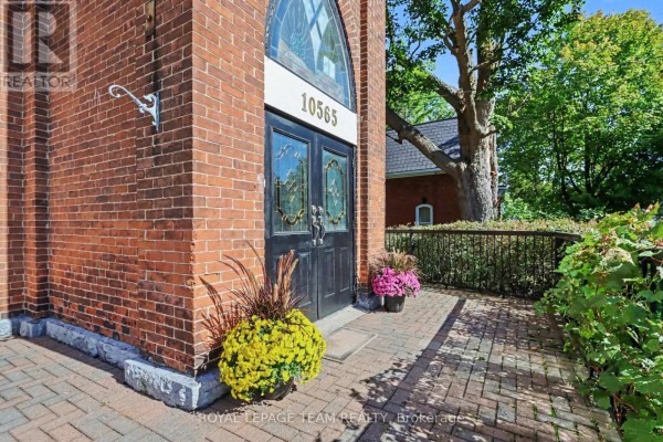 Close-up of the black double doors of the church entrance with decorative glass. - 10565 Main Street, North Dundas