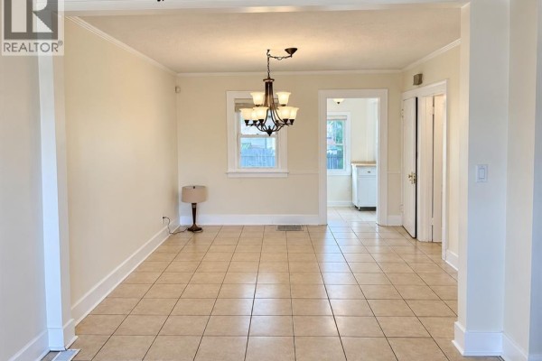 Interior view of a room with tiled floors, a ceiling fan, and a front door. - 1057 Ellis Street, Windsor