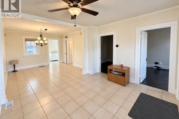 Interior view of a dining area with tiled floors and a chandelier. - 1057 Ellis Street, Windsor