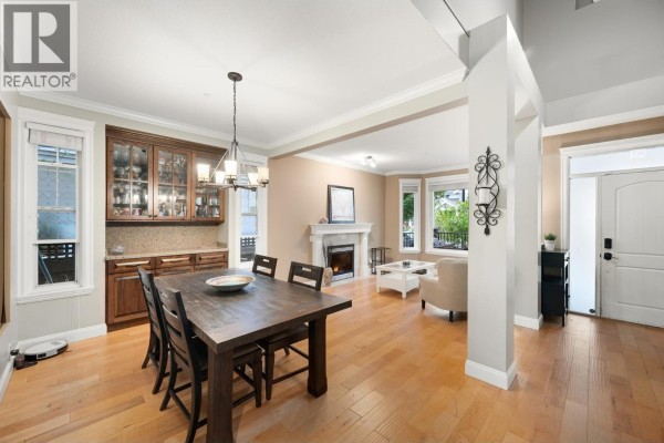 Open-concept dining room and living room with a fireplace and large windows. - 10574 239 Street, Maple Ridge