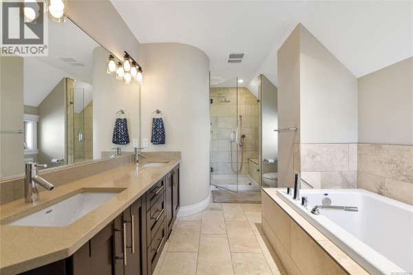 Spacious bathroom with dual sinks, a large soaking tub, and a glass-enclosed walk-in shower. - 1059 Clare St, Victoria