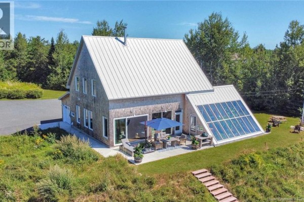 Front view of the house with a patio, outdoor furniture, and large sunroom. - 1059 Nb-365, Gauvreau